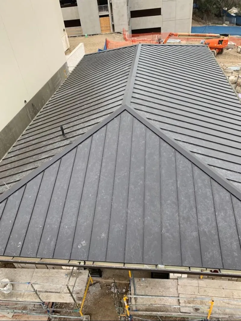 Commercial metal roof construction with crane equipment in Epping